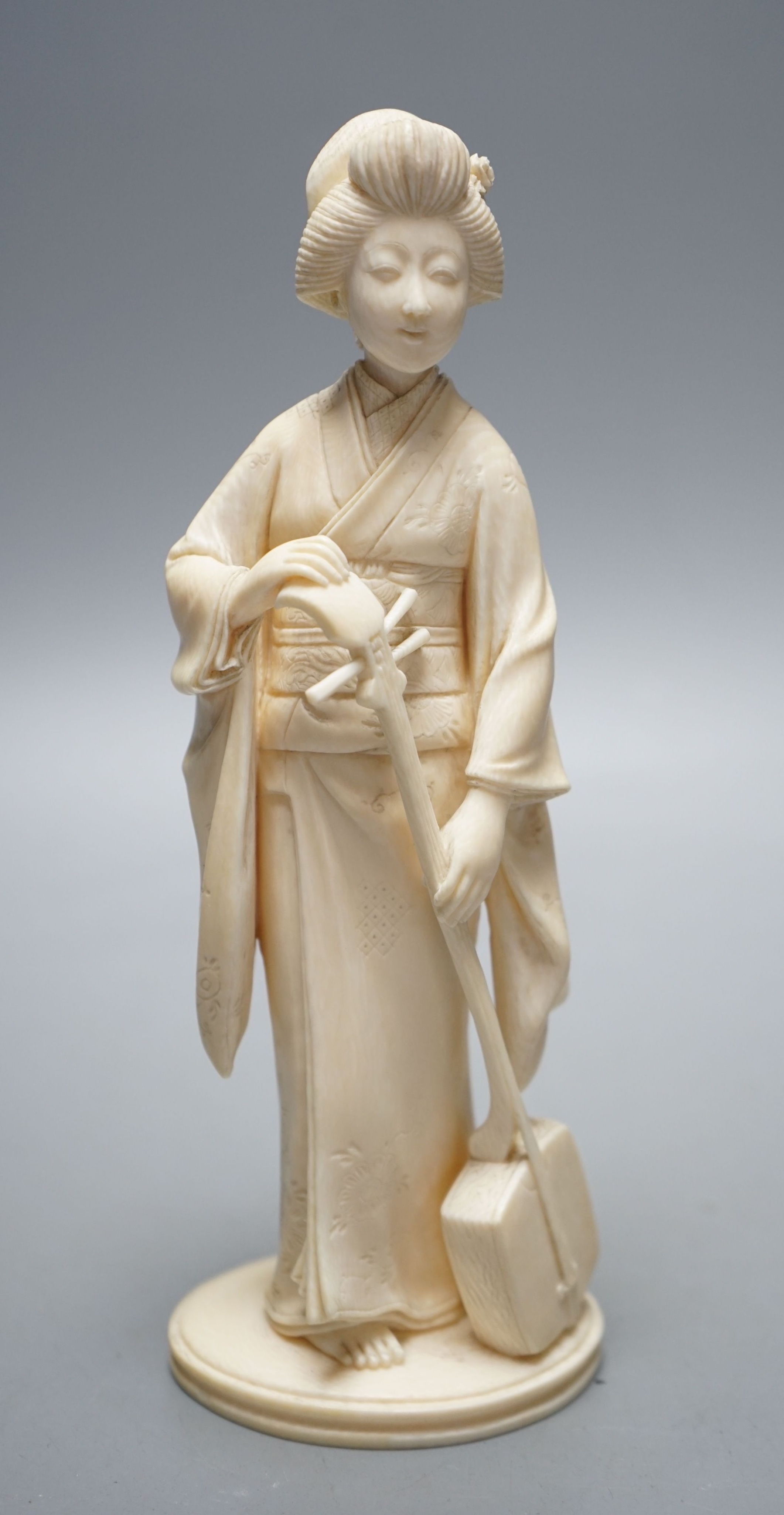 A Japanese Meiji period okimono of a lady with a musical instrument, 19 cms high.